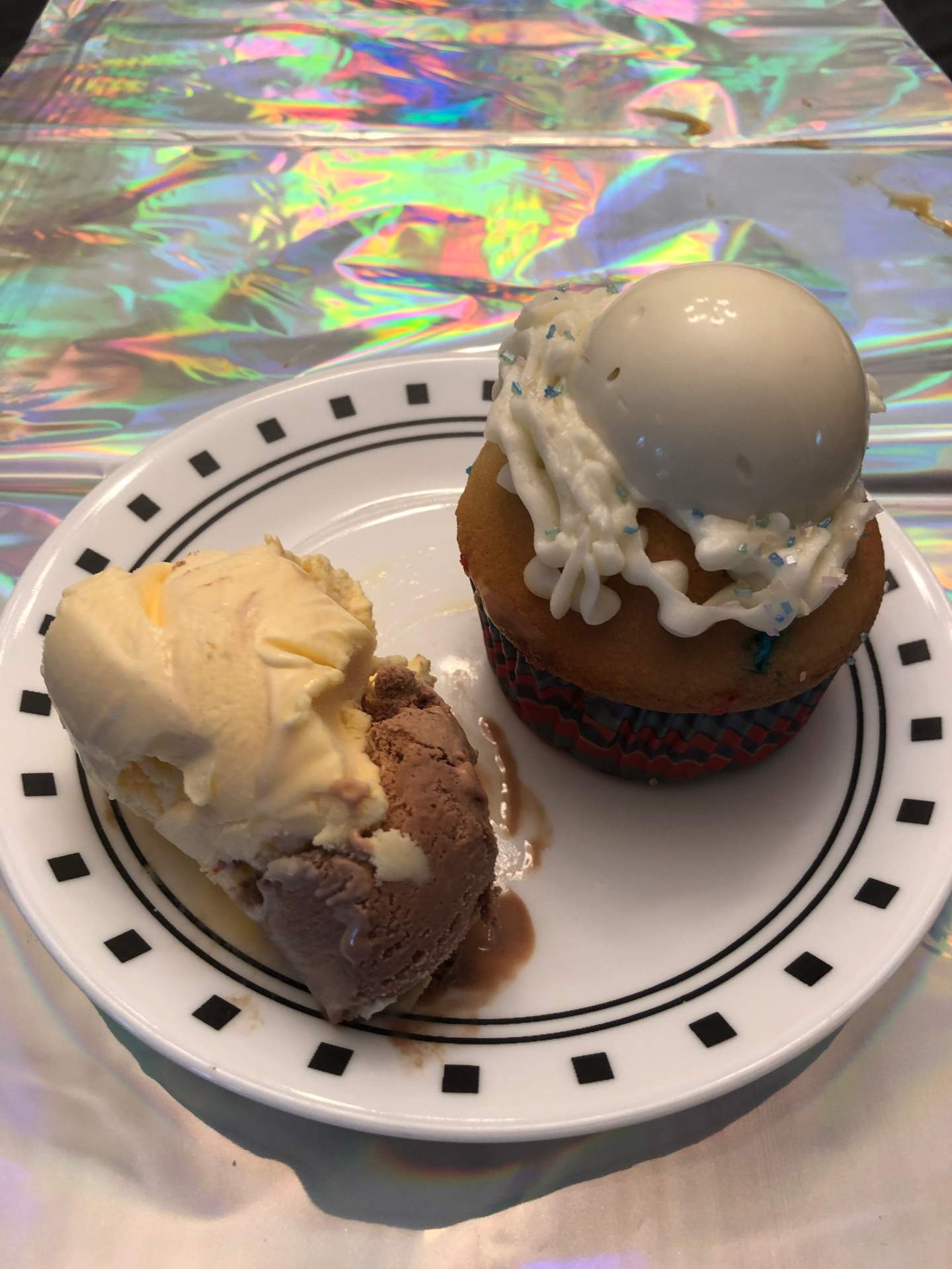 Confetti cupcake with buttercream and molded white chocolate on top, with ice cream